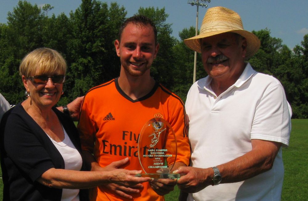 Matt Penello of Soccer Plus Junction receives the Mens Trophy from Margaret and Fred Forster